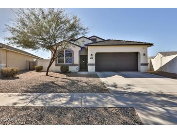 Charming single-story home featuring a two car garage, desert landscaping, and a cozy front porch at 454 N 19Th Pl, Coolidge, AZ 85128