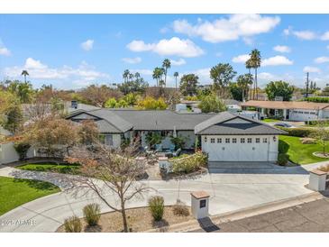 Stunning single-story home with a spacious driveway, 3-car garage, mature landscaping, and a cozy outdoor seating area at 5201 N 33Rd St, Phoenix, AZ 85018