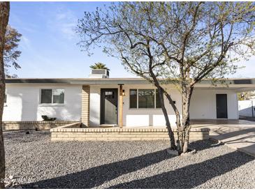 Charming one-story home featuring neutral paint, desert landscaping, and an inviting front porch at 718 W Vine Ave, Mesa, AZ 85210