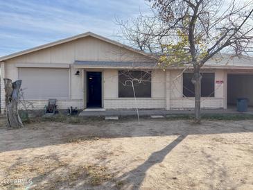 Modest single-story home with low landscaping, an open front door and an inviting facade at 723 E Garnet Ave, Mesa, AZ 85204