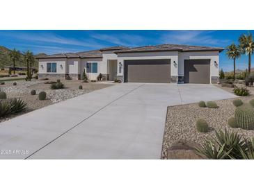 Stunning home featuring desert landscaping, neutral colors, and a wide driveway leading to a two-car garage at 9278 E Cloudview Ave, Gold Canyon, AZ 85118