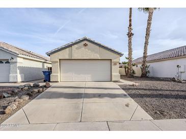 Attached two-car garage featuring neutral paint, a well-maintained driveway and desert landscaping at 1780 E Countrywalk Ln, Chandler, AZ 85225