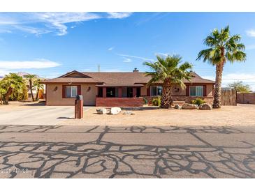 Charming single-story home with desert landscaping and mature palm trees, creating an inviting curb appeal at 2031 S Cactus Rd, Apache Junction, AZ 85119