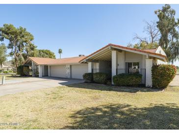 Charming single-story home featuring a terra cotta tile roof, attached garages, and a well-manicured lawn at 4843 E Ajo Cir, Phoenix, AZ 85044