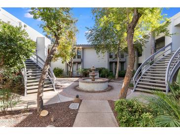 Picturesque courtyard view showcasing a beautiful fountain, mature trees, and well-maintained landscaping at 5223 N 24Th St # 108, Phoenix, AZ 85016