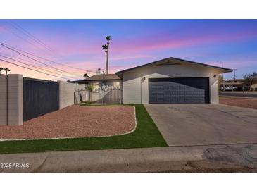 Charming single-story home featuring a two-car garage and a low-maintenance front yard under a beautiful purple sky at 5942 W Seldon Ln, Glendale, AZ 85302