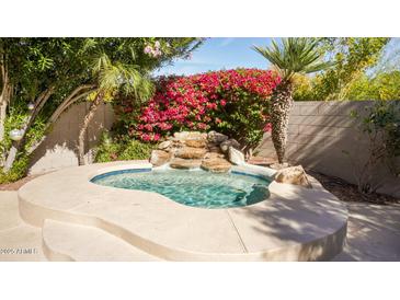 Inviting pool with rock waterfall feature and lush landscaping creates a backyard oasis at 7500 E Deer Valley Rd # 59, Scottsdale, AZ 85255