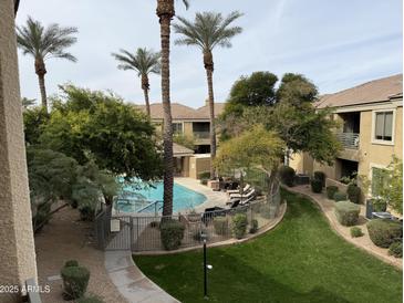 Community pool featuring palm trees, chaise lounges, grass and lush landscaping in a desert climate at 7887 N 16Th St # 227, Phoenix, AZ 85020