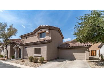 Two story home with a neutral colored exterior, attached garage and low maintenance front yard at 8134 W Beck Ln, Peoria, AZ 85382