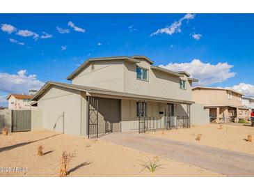 Two-story home with neutral color scheme and attached garage in a neighborhood with mature desert landscaping at 8248 W Whitton Ave, Phoenix, AZ 85033