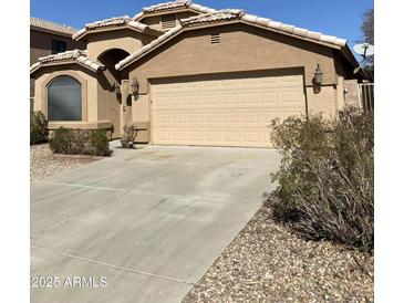 Charming home exterior featuring a two-car garage and well-maintained landscaping at 8648 W Fargo Dr, Peoria, AZ 85382