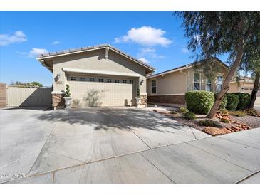 Charming home with a two-car garage, stone accents, desert landscaping, and a spacious driveway at 9010 W Ruth Ave, Peoria, AZ 85345