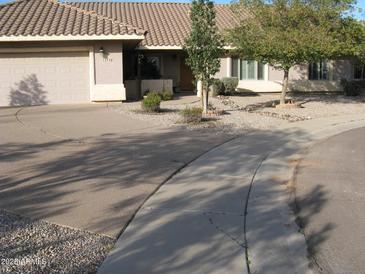 Charming single-story home with a well-manicured front yard, tile roof, and attached two-car garage at 1112 E Shepherds Way, Casa Grande, AZ 85122