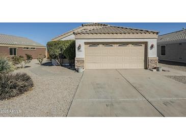 Attached garage with concrete driveway and desert landscaping in front yard at 1186 E Bradstock Way, San Tan Valley, AZ 85140