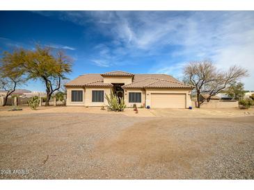 Beige single story home showcasing desert landscaping and an attached two car garage at 34242 N 10Th St, Phoenix, AZ 85085