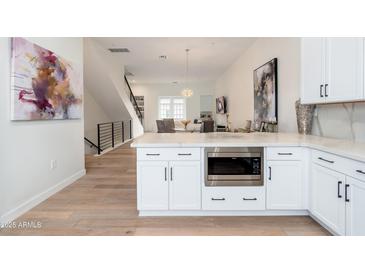 Open-concept kitchen with white cabinets, stainless steel appliances, and an island with a built-in microwave at 4438 N 27Th St # 24, Phoenix, AZ 85016