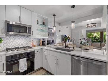 Modern kitchen featuring white cabinets, stainless steel appliances, and stylish backsplash at 7157 E Rancho Vista Dr # 6011, Scottsdale, AZ 85251