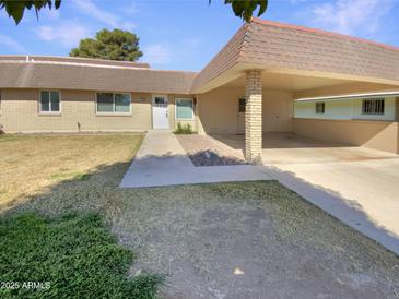 Inviting single-story home featuring a covered carport, low maintenance landscaping, and a welcoming front entrance at 9814 N Balboa Dr, Sun City, AZ 85351