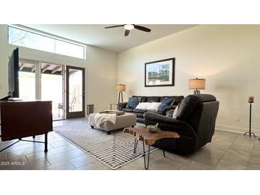 Bright living room boasts a large window, sliding glass door, tile flooring and comfortable furniture at 11772 E Clinton St, Scottsdale, AZ 85259