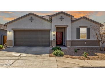 Charming single-story home with a two-car garage and a well-maintained desert landscape at 38145 W Amalfi Ave, Maricopa, AZ 85138