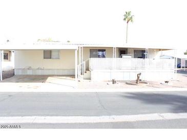 Exterior view of a mobile home with a covered parking area and small front yard at 9501 E Broadway Rd # 237, Mesa, AZ 85208