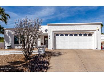 Charming one-story home with a well-maintained front yard and a two-car garage at 1202 E Winged Foot Rd, Phoenix, AZ 85022