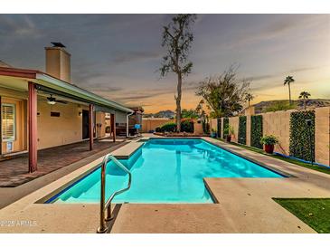 Sparkling pool surrounded by lush landscaping, perfect for relaxation and outdoor enjoyment at sunset at 13234 N 2Nd St, Phoenix, AZ 85022