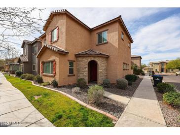 Charming two-story home with neutral stucco, red shutters, stone archway entrance, and fresh landscaping at 1835 W Minton St, Phoenix, AZ 85041