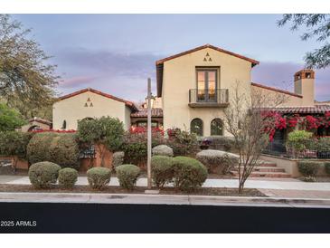 Charming stucco home with a balcony, clay tile roof, lush landscaping and beautiful bougainvillea at 20299 N 102Nd Pl, Scottsdale, AZ 85255