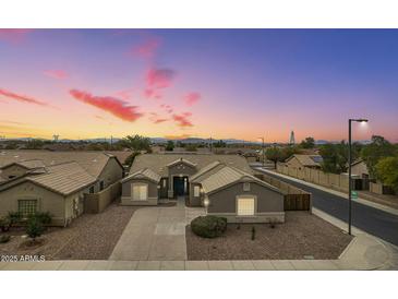 Charming single-story home featuring desert landscaping, warm lighting, and a welcoming entrance at 22949 W Yavapai St, Buckeye, AZ 85326