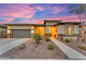 Charming single-story home with desert landscaping, a two-car garage and a welcoming front porch at 23004 E Desert Spoon Dr, Queen Creek, AZ 85142