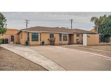 Charming home with a concrete driveway, xeriscaped yard, and tan exterior at 2929 N 55Th Pl, Phoenix, AZ 85018