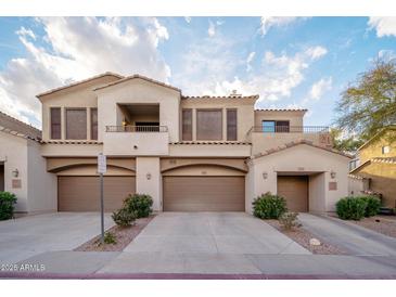 Inviting two-story townhome featuring a private balcony and attached two-car garage, set against a backdrop of a blue, cloudy sky at 3131 E Legacy Dr # 2101, Phoenix, AZ 85042