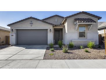 Charming single-story home with a two-car garage, desert landscaping, and neutral stucco facade at 31400 N 130Th Ave, Peoria, AZ 85383