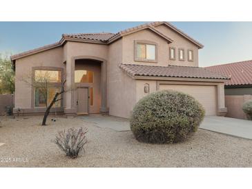 Inviting tan stucco home featuring a tile roof, desert landscaping, and an attached two-car garage at 4625 E Thorn Tree Dr, Cave Creek, AZ 85331