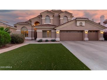 Charming two-story home featuring a tile roof, stucco exterior, well-manicured lawn, and a two-car garage at 5545 E Helena Dr, Scottsdale, AZ 85254