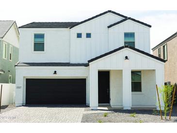 Charming two-story home boasts a modern design with black garage door and white trim at 5708 S Daisy Patch Pl, Phoenix, AZ 85040