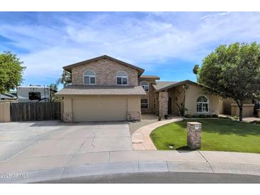 Charming two-story home featuring a lush lawn, stone accents, and a spacious driveway at 609 W Mcnair St, Chandler, AZ 85225