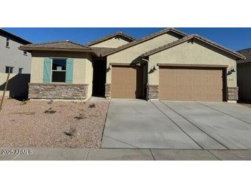 Charming single-story home features a stone facade, two-car garage and neutral-colored stucco at 7050 E Brushy Bill Rd, San Tan Valley, AZ 85143