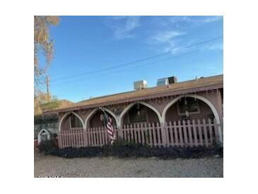 Charming single-story home featuring an arched porch with a quaint picket fence and an American flag at 885 E Commonwealth Pl, Chandler, AZ 85225