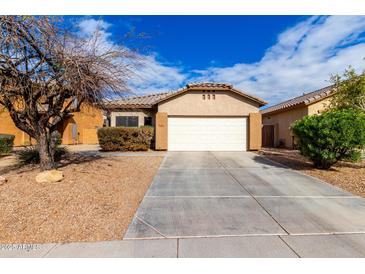 Charming one-story home with a low maintenance front yard and white garage door at 8850 W Laurel Ln, Peoria, AZ 85345