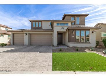 Charming two-story home with a three car garage, manicured landscaping and brick paved driveway at 11679 W Parkway Ln, Avondale, AZ 85323