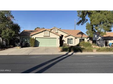 Charming single-story home featuring a well-maintained lawn and a two-car garage at 14440 N 56Th Pl, Scottsdale, AZ 85254