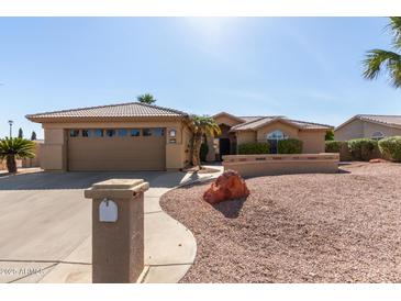 Charming single-story home with a well-manicured desert landscape and a two-car garage at 15479 W Whitton Ave, Goodyear, AZ 85395