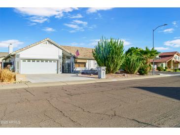 Single story home showcasing front yard desert landscaping and three-car garage at 16029 N 36Th Dr, Phoenix, AZ 85053