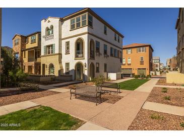 Charming three-story townhome featuring classic architectural details and a well-manicured lawn at 1677 E Bridgeport Pkwy, Gilbert, AZ 85295