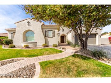 Charming stucco home showcasing mature landscaping, a brick walkway, and a two-car garage at 30488 N 126Th Dr, Peoria, AZ 85383