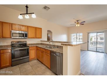 Bright kitchen features stainless steel appliances, a breakfast bar, and an open floor plan at 320 N 168Th Dr, Goodyear, AZ 85338