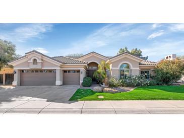 Charming single-story home featuring a three-car garage and lush landscaping at 5507 E Shea Blvd, Scottsdale, AZ 85254