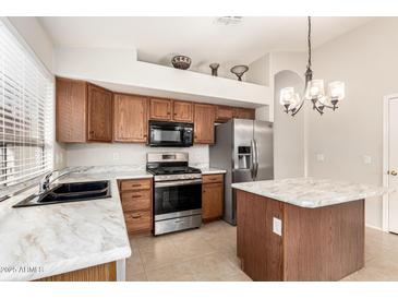 Well-lit kitchen with stainless steel appliances, a gas range, and island with marble countertop at 757 E Lovegrass Dr, San Tan Valley, AZ 85143